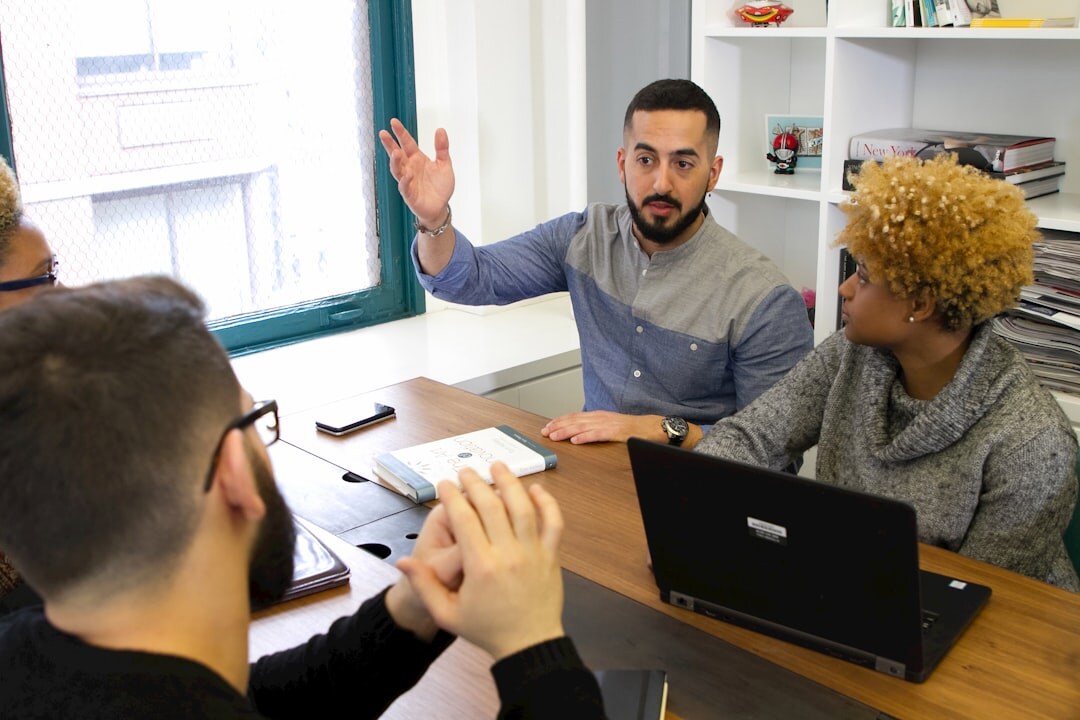 Small team having a discussion around a table in a bright office